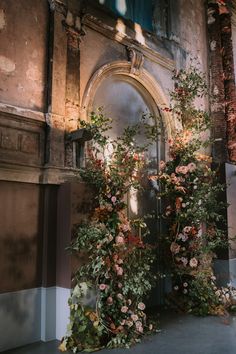 flowers are growing on the side of an old building