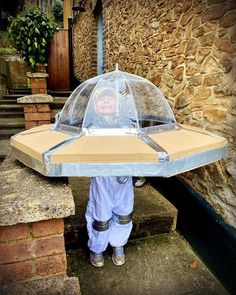 a little boy holding an umbrella over his head