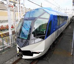 a train that is sitting on the tracks near some buildings and power lines with wires above it