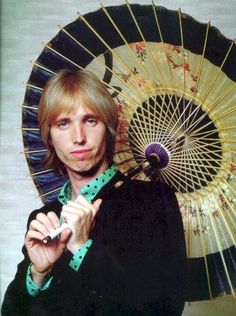 a woman holding an umbrella in front of her face and posing for the camera with it's hand