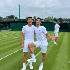 two tennis players pose for a photo on the court