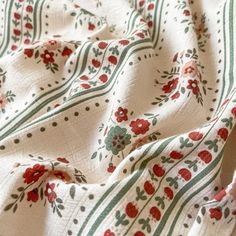 the fabric has flowers on it and is white with green stripes, which are striped in red