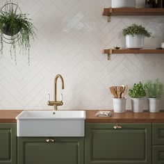 a kitchen with green cabinets and white tiled backsplash, brass faucet