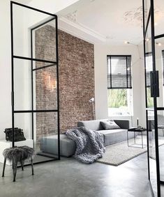 a living room with brick walls and glass partitions