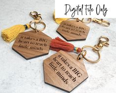 four wooden key chains with tassels on them and the words, it takes a big heart to teach little minds