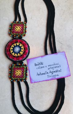 a necklace with some beads on it and a sign that says, heikt