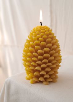 a yellow candle sitting on top of a white table