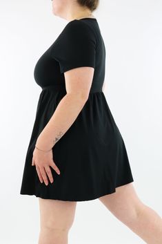 Black Mini Dress features short sleeves, invisible pockets, and a modest neck line, in an above the knee mini style. NEW SIZING Range: Mini Length DressStyle: Short Sleeve - Mini - Skater Dress Size Recommendation: If in between sizes, size down for a firmer fit, size up for a looser fit. Made with curves in mind Sizes 6-28 Two side pockets Modest neckline short sleeves Above the knee, mini length style Suitable for curvy body types Relaxed fit vintage style Plain Black Made for comfort A special soft to touch brushed fabric (cottony soft) Polyester/spandex blend (like the casual leggings) Stretches 3-4 sizes with ease Model 1 wears: size S/M - Stats: 12/14 (AUS), Hips 117cm, Waist 93cm, Bust 107cm, Height 164cm. Dresses For Curvy Women, Black Mini Dresses, Curvy Body Types, Black Sundress, Modest Neckline, Casual Leggings, Fleece Leggings, Plus Size Black, Mini Skater Dress