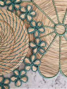 two baskets with blue and green trims on top of a marble counter next to an umbrella