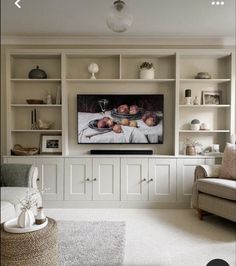 a flat screen tv sitting on top of a white entertainment center in a living room