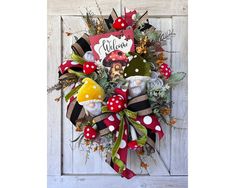 a wreath with gnomes and mushrooms is hanging on the front door to welcome guests