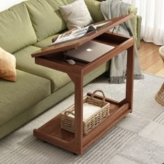 a laptop computer sitting on top of a wooden table in front of a green couch