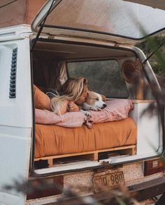 a woman laying on top of a bed in the back of a truck