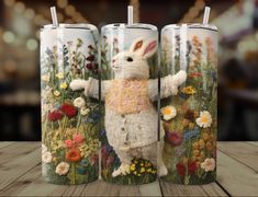 two mugs with an image of a rabbit and flowers on the front one has a straw in its mouth