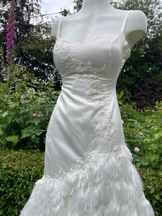 a white wedding dress with feathers on it