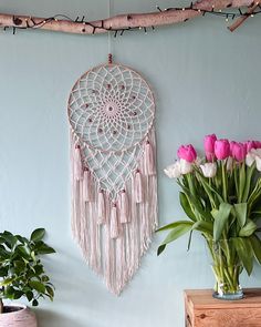 a vase with flowers in it next to a wall hanging