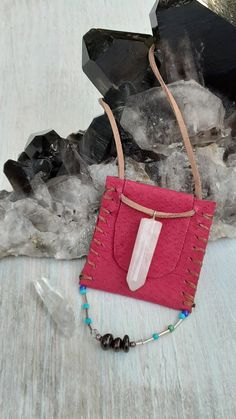 a pink bag sitting on top of a table next to crystals