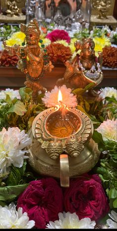 a lit candle is surrounded by flowers and candles