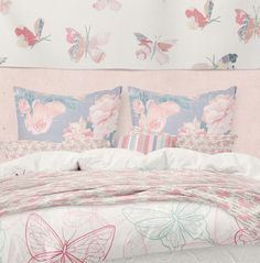 a bed with pink flowers and butterflies on it