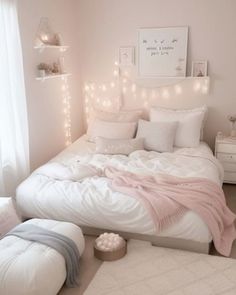 a white bed with pink blankets and pillows in a room decorated for christmas or new year's eve