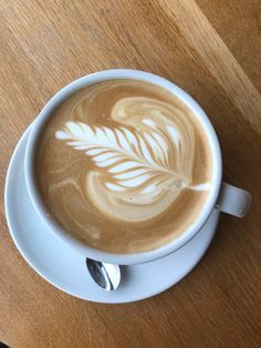 a cappuccino with a leaf drawn on it