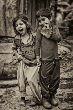 two children standing next to each other with their mouths open