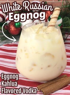 an eggnog drink in a glass with cinnamon sticks