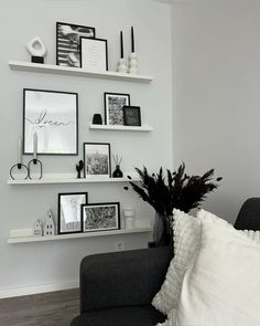 a black and white living room with pictures on the wall, vases and shelves