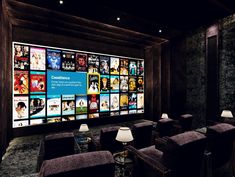 an empty movie theater with several chairs and large screens on the wall behind them that are full of movies