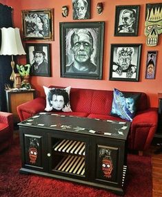 a living room filled with red couches and pictures on the wall above it's coffee table