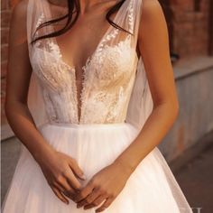 a woman in a wedding dress posing for the camera with her hands on her hips