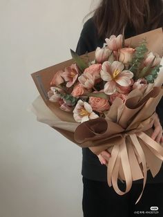 a woman holding a bouquet of flowers in her hands