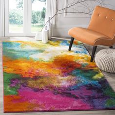 a colorful area rug with an orange chair in the corner and a window behind it