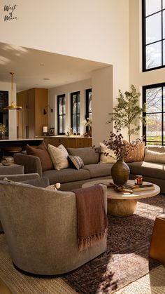 a living room filled with furniture and large windows