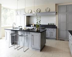 a large kitchen with gray cabinets and black counter tops