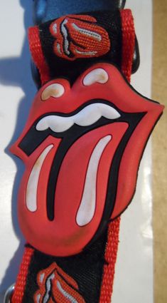 the rolling stones tongue band strap is red and black, with white teeth on it