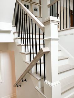 a white staircase with black railing and handrails