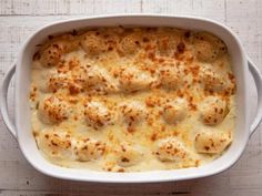 a casserole dish with chicken and cheese in it on a white table top