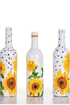 three vases painted with sunflowers and polka dots on the bottom one is white