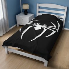 a bed with a black and white spiderman comforter