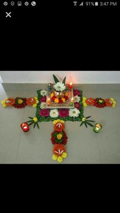 an arrangement of flowers and candles on the floor