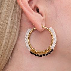 Experience the elegance of Okamapa hoop earrings – hand woven with intricate Miyuki beads into a timeless display of white, black and gold colors. Drawing its name from the Embera language meaning "hoop", Okamapa is a classic look with a luxurious edge. White Elegant Woven Jewelry, Elegant White Woven Jewelry, White Beaded Earrings With Black Beads, White Hoop Earrings With Tiny Beads, White Tiny Beads Small Hoop Earrings, White Tiny Beaded Small Hoop Earrings, White Small Hoop Beaded Earrings, White Small Hoop Beaded Earrings With Tiny Beads, White Beaded Hoop Earrings