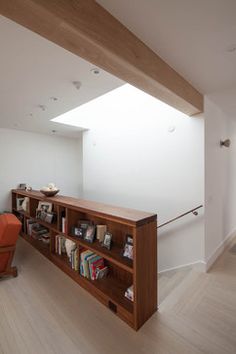 a bookshelf in the middle of a room with white walls and wood flooring