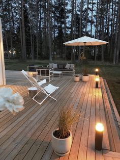 an outdoor deck lit up with candles and chairs