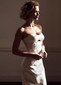 a woman in a strapless dress poses for a photo