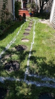 a yard with grass and stepping stones in it