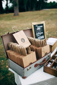 an open suitcase sitting on top of a table filled with paper bags and other items