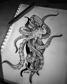 an octopus drawing on paper next to a pen