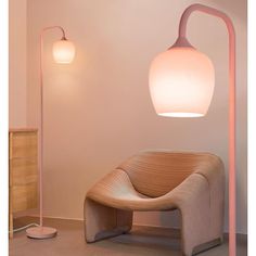 a pink floor lamp next to a chair