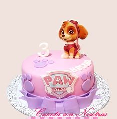 a pink cake with a dog on top and the number three in front of it